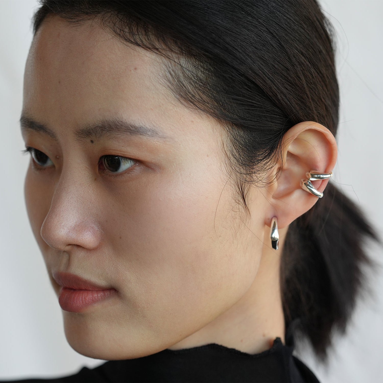 Model wearing two silver Ono Ear Cuffs.